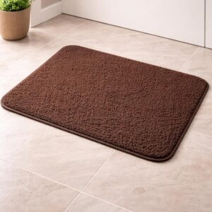 Brown anti-skid bath mat placed on a tiled bathroom floor near a door with a soft textured surface