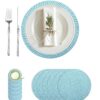 Blue and white woven braided placemat set arranged on a dining table with a white plate, napkin, fork, and knife.